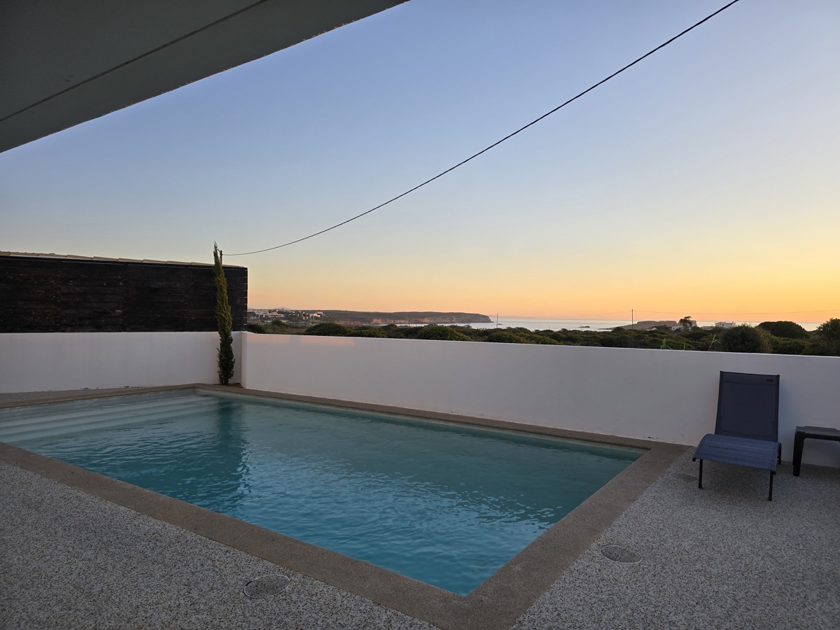 Villa pool at sunrise with coastal cliffs view
